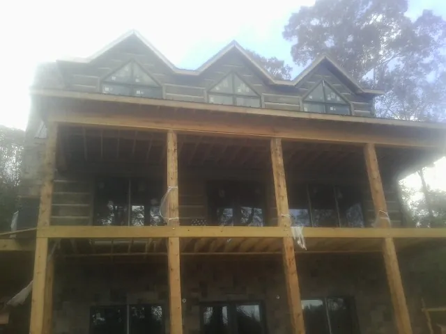 Dormers and porch framing on a large log home under construction — Roof Coating work by our crew in Landisville